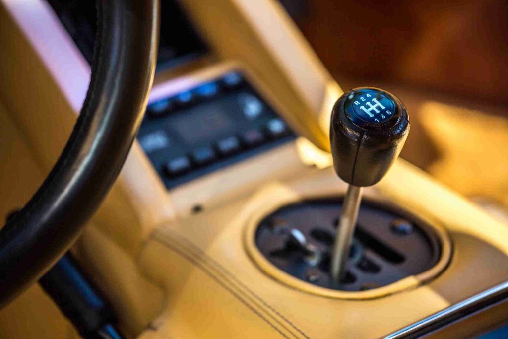 Vehicle interior showing the gear shifter. Crucial car components like the transmission and steering system must be maintained to prevent emergencies like power steering failure.