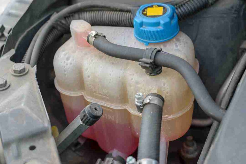 Close-up of a radiator coolant reservoir with low coolant level in a car engine bay